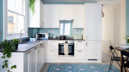 modern white kitchen with blue walls and blue rug