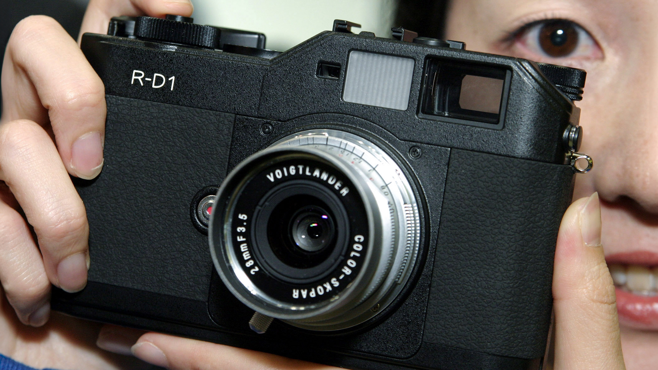 A Seiko Epson Corp. attendant holds the world's first rangefinder digital camera, Seiko Epson's R-D1, at the Photo Expo 2004 in Tokyo, Japan Friday, March 19, 2004. (Photo by Haruyoshi Yamaguchi/Bloomberg via Getty Images)