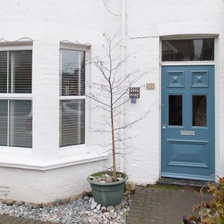white wall house exterior with blue door