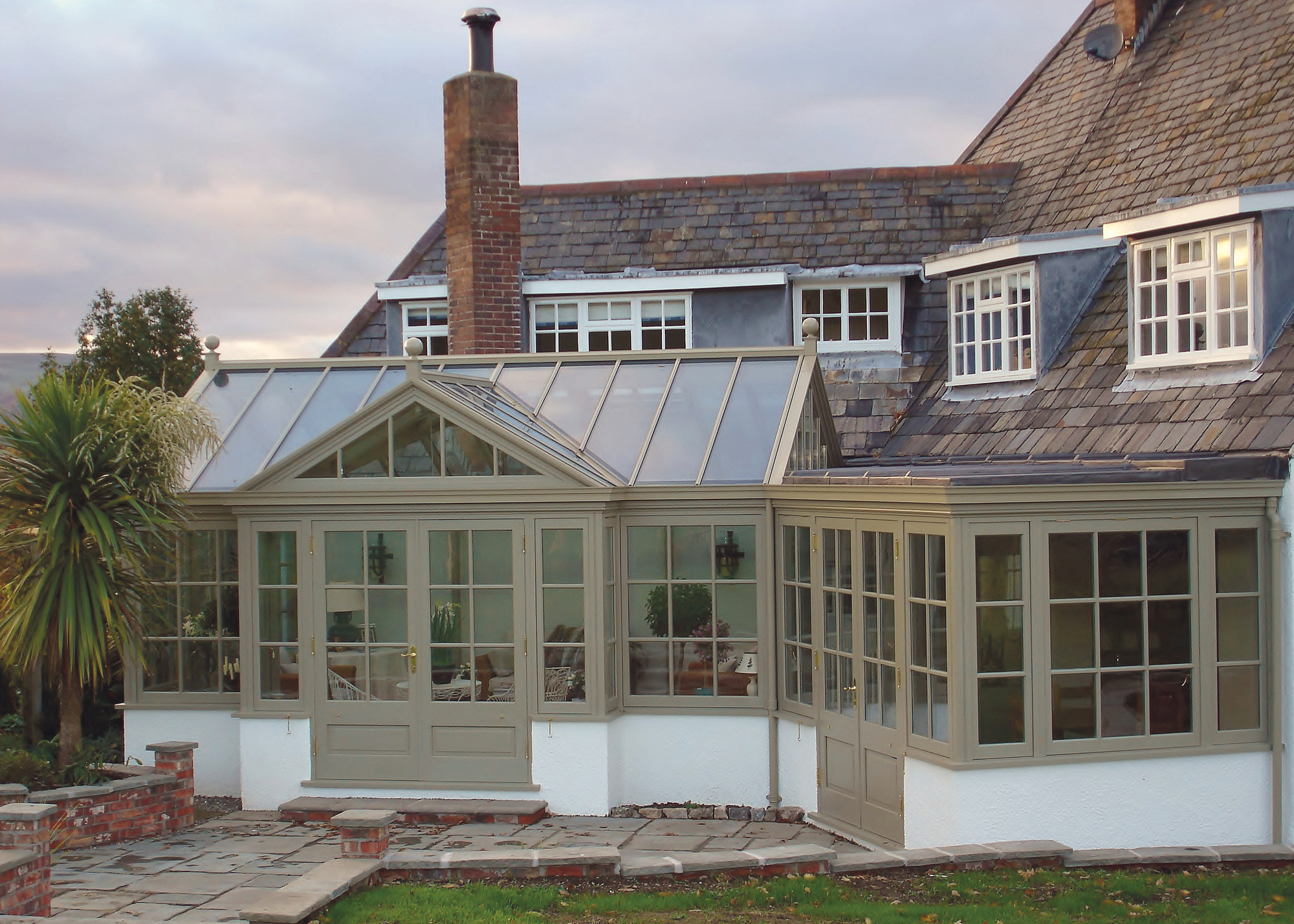 conservatory exterior painted sage green with a view of the rest of the home