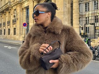 Woman wearing faux fur jacket and The Row '90s bag