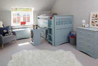 blue loft bed with stoprage and built in besk in childs bedroom