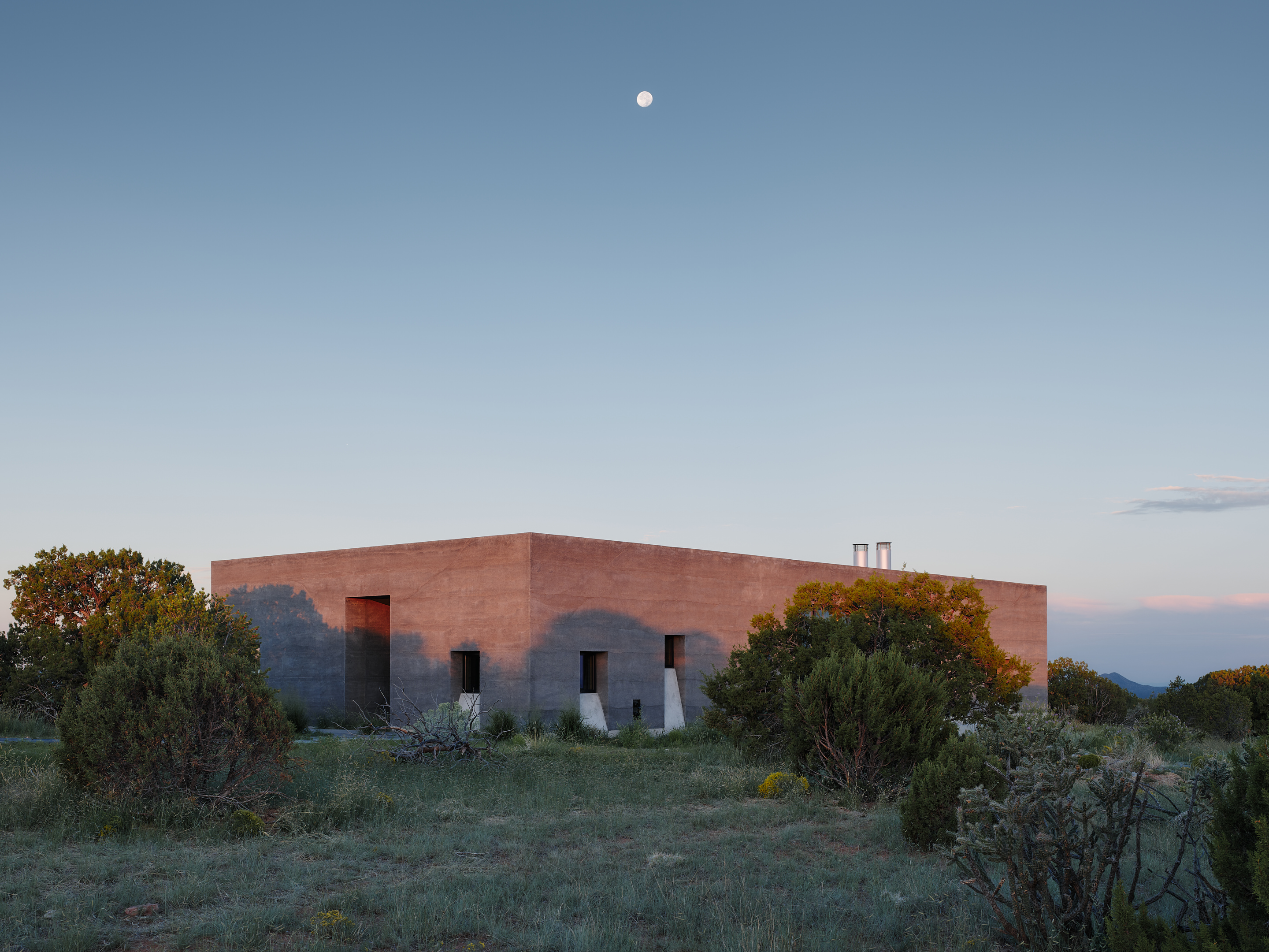 views of Sombra de Santa Fe, new mexico house, with dark, minimalist geometric volumes and clean walls and long nature views
