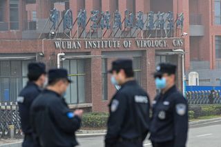 Security personnel stand guard outside the Wuhan Institute of Virology in Wuhan as members of the World Health Organization (WHO) team investigating the origins of the COVID-19 coronavirus make a visit to the institute on February 3, 2021.