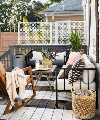A decking scheme with monochrome striped flooring decor, wooden coffee table and assortment of mixed seating
