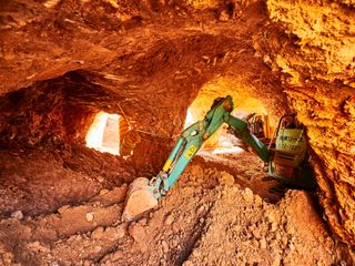 Digger among rubble in cave