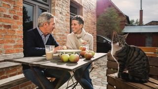 Couple eating outside with cat