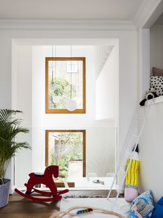A white playroom with mezzanine level with the bed on top