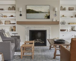 A neutral living room with grey armchairs, wooden fittings and a Samsung Frame over the mantle