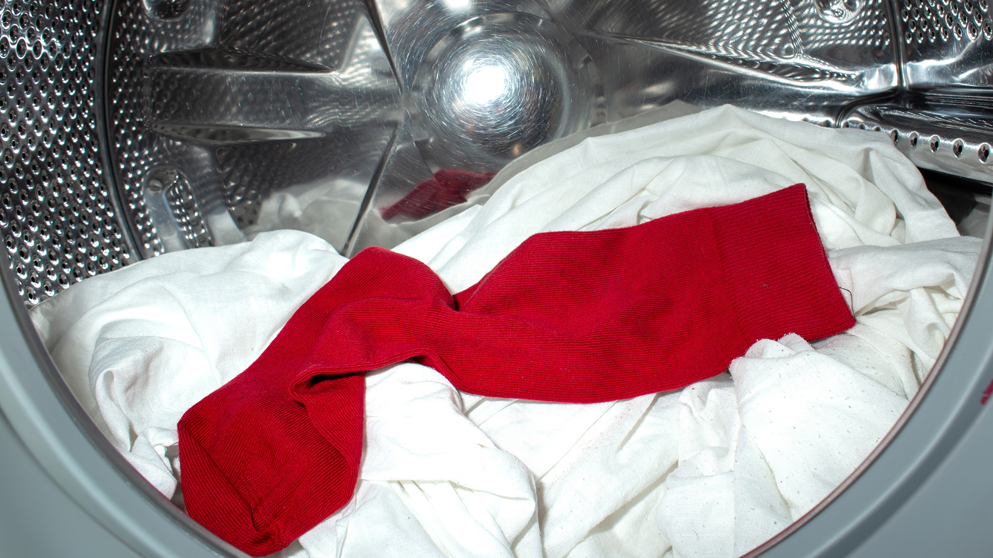 Red sock in washing machine with white garments