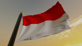 Indonesian flag waving in front of yellow sky