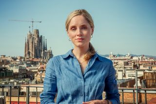 Sophie Rundle in The Diplomat standing against a backdrop of Barcelona. 