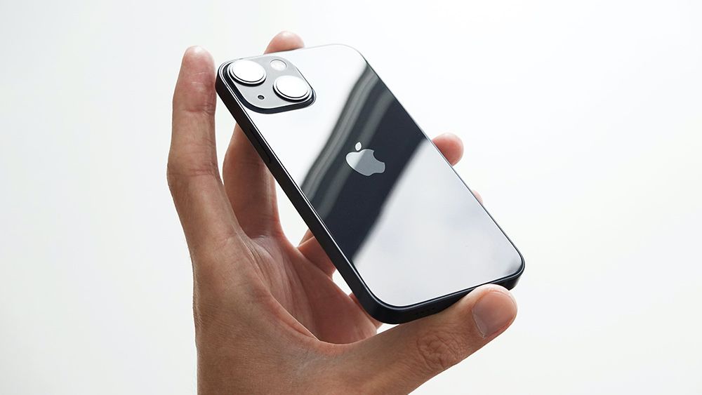 A hand holding an iPhone 13 