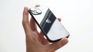 A hand holding an iPhone 13 