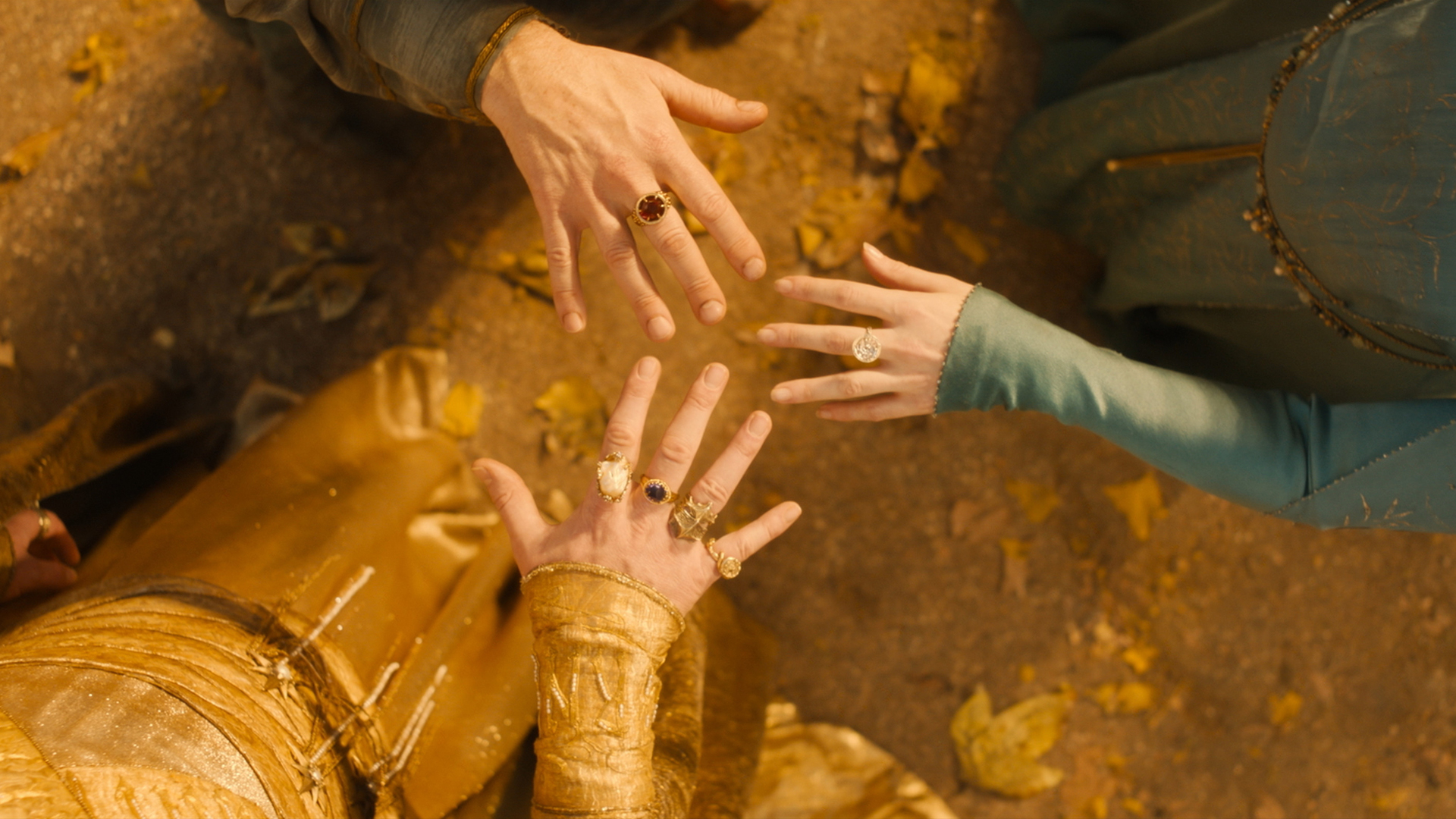 A screenshot of the three elven rings on the middle fingers of Gil-Galad, Cirdan and Galadriel in Season 2 of “The Rings of Power”