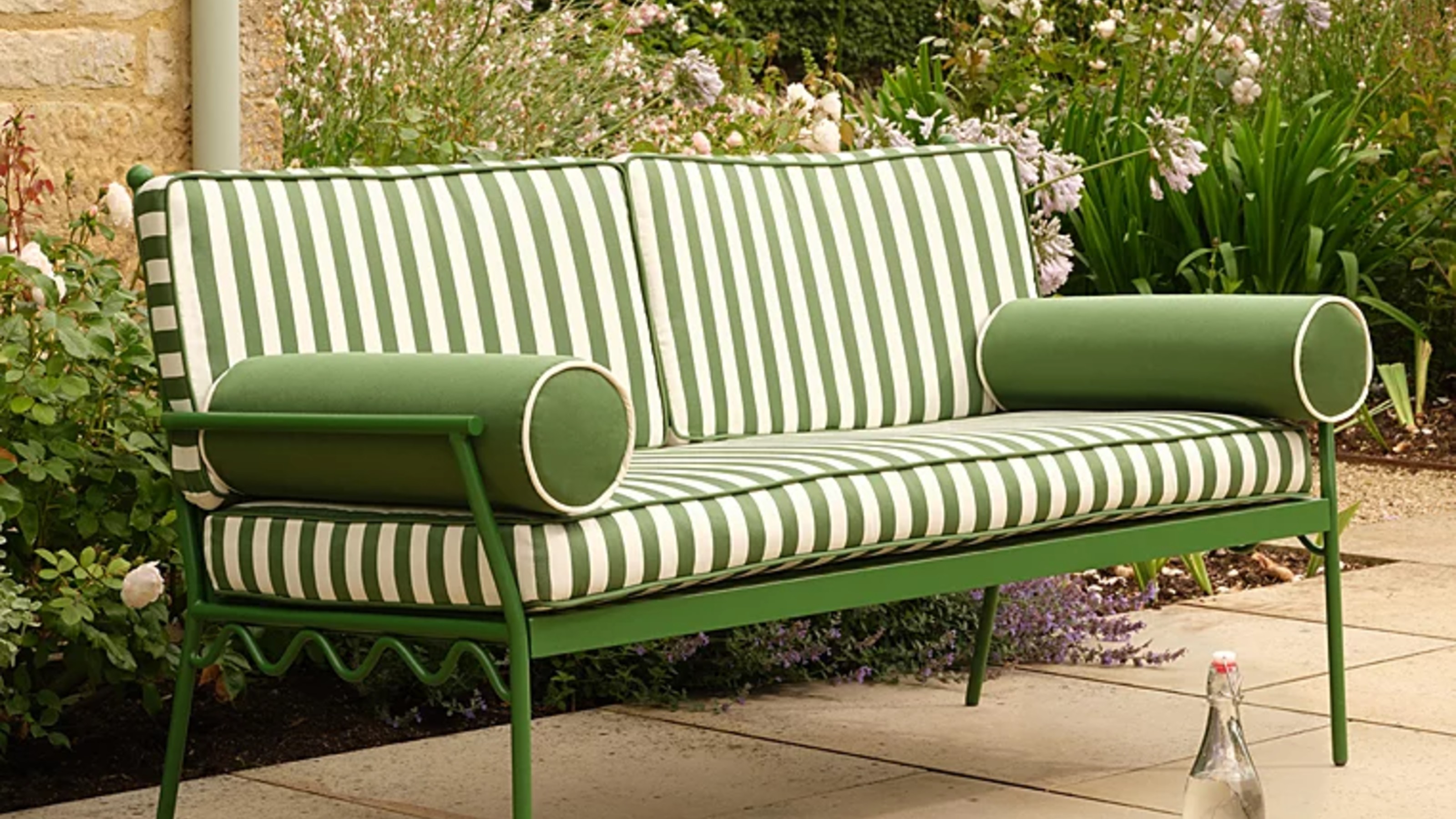 George Home Riviera Green and White Stripe Metal Garden Bench in a garden