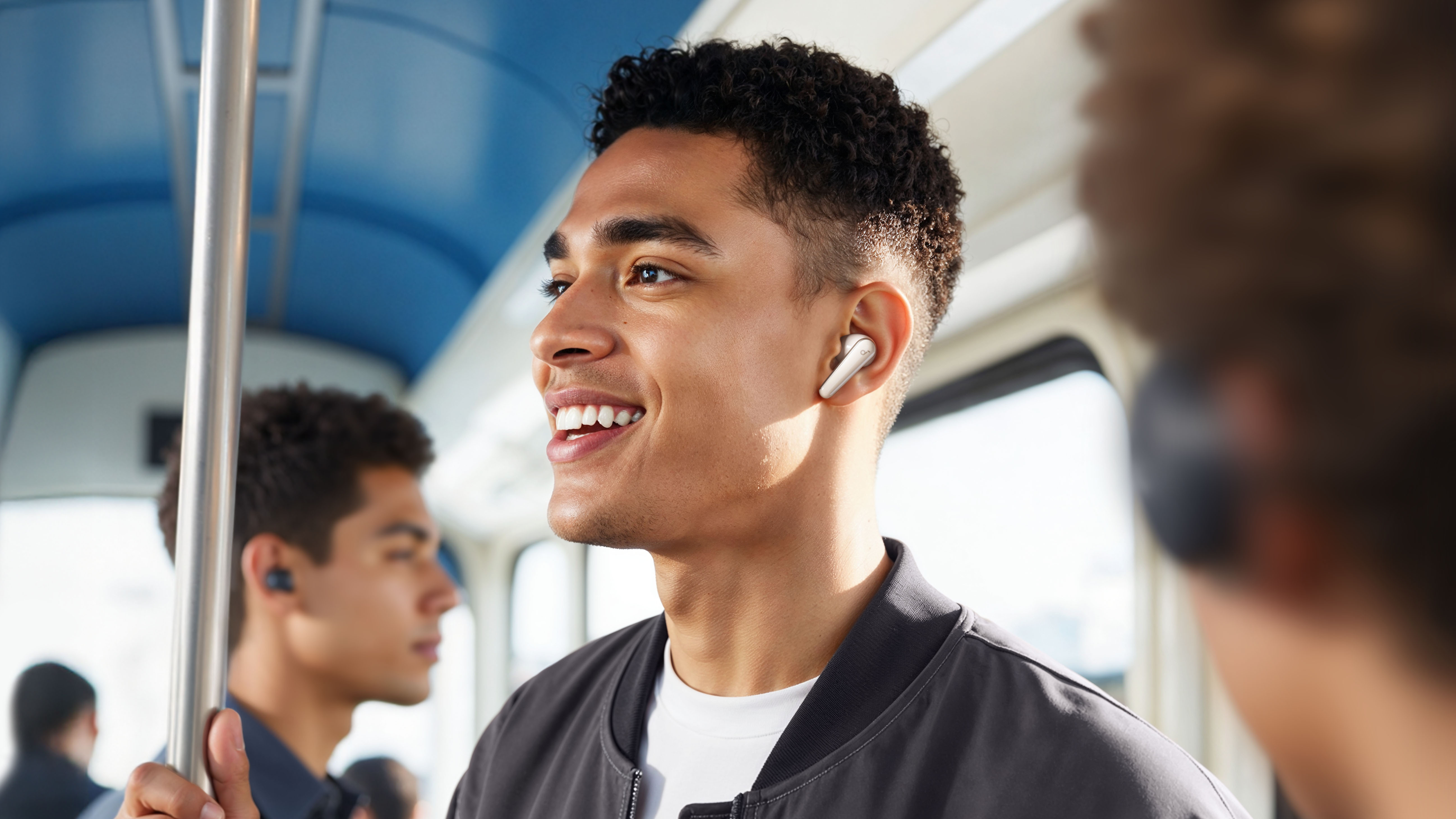 A young man wearing a pair of Soundcore Liberty 5 earphones while riding public transport.