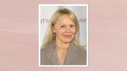 Image of Pamela Anderson smiling with long blonde hair and curtain bangs, wearing a taupe coloured blazer, on a soft pink background