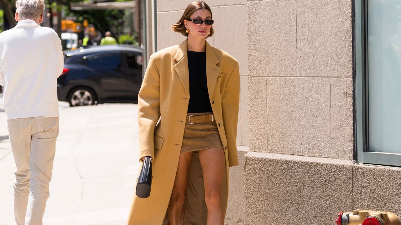 Hailey Bieber in tan coat and mini skirt GettyImages-1488894433