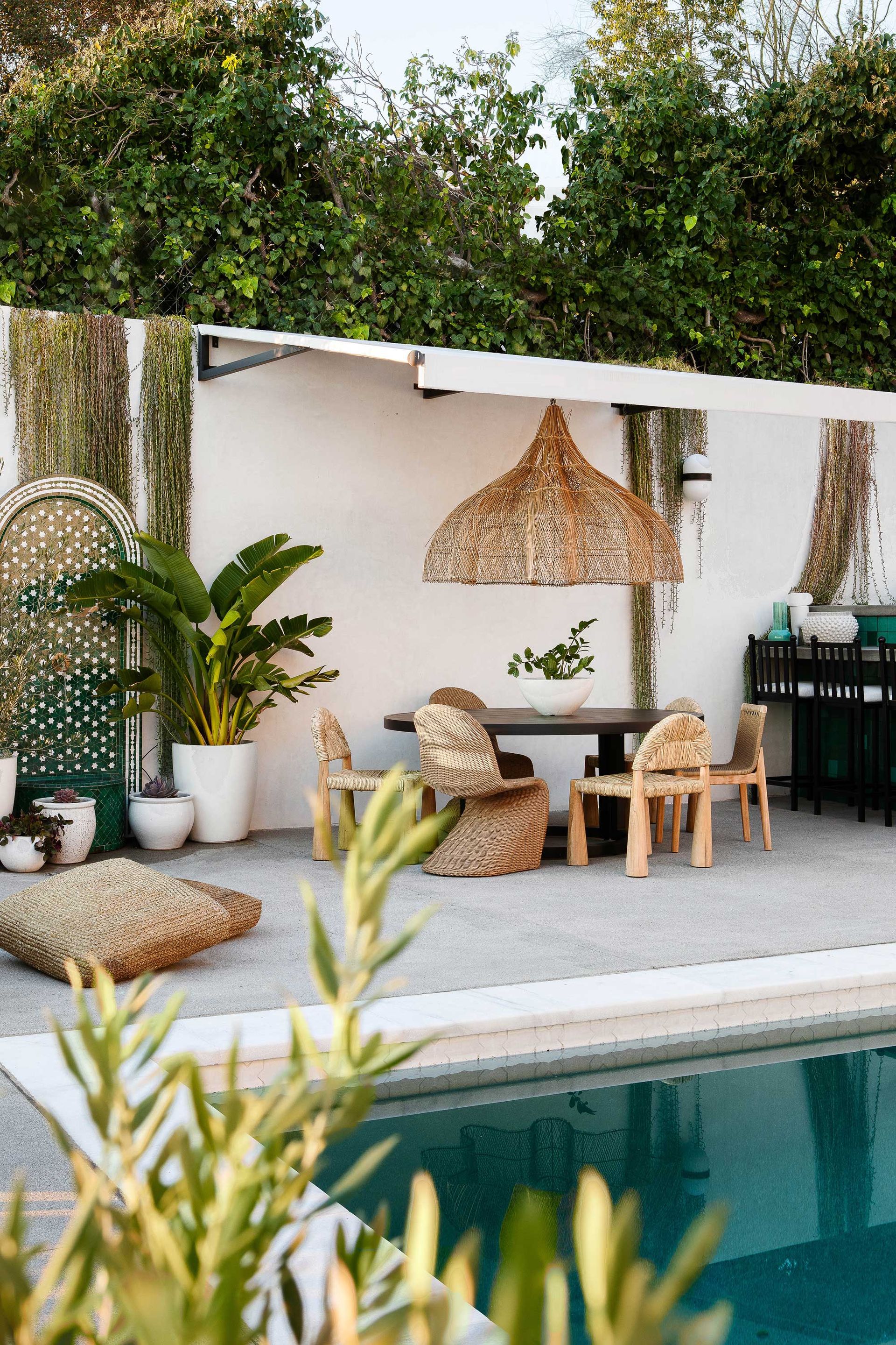 an outdoor dining table with a cane light above it