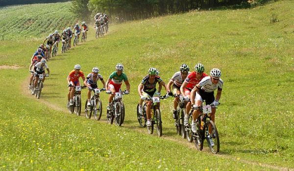 The men speed through some grassy singletrack early in the race.