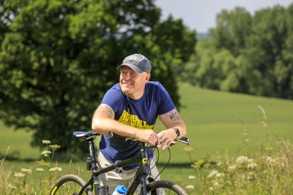 Mark Hodson smiling, leaning on his bike
