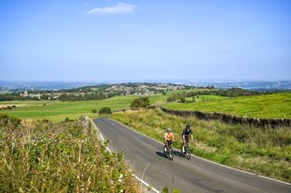 two cyclists ride side by side