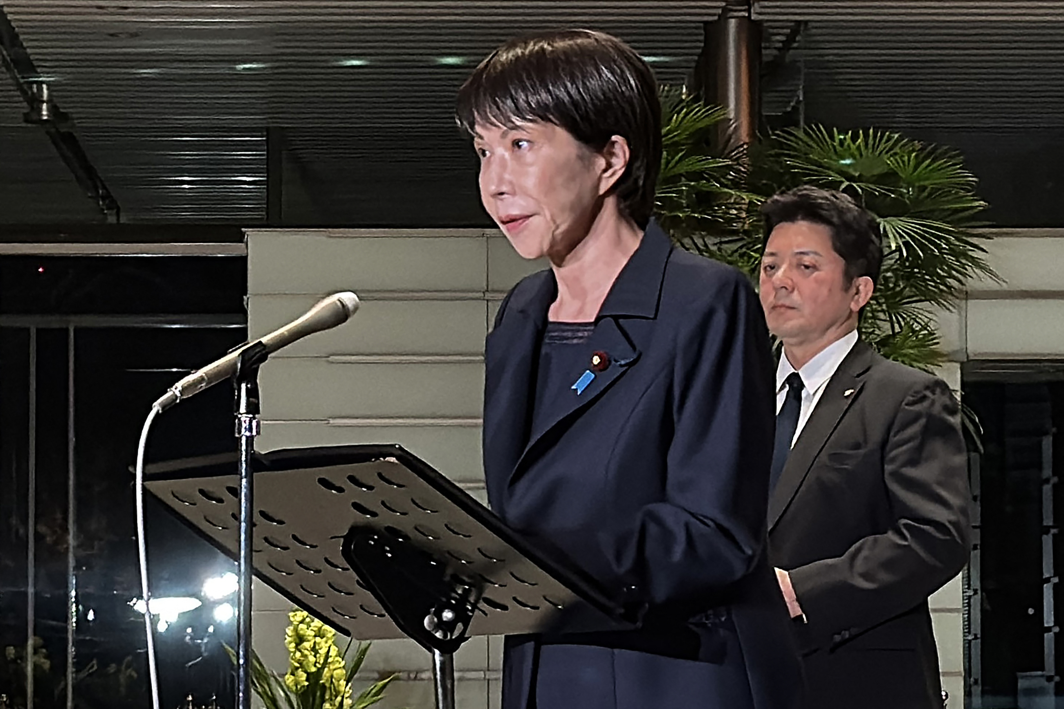 A photo of the Prime Minister of Japan, Sanae Takaichi, addressing the media following the country&#039;s magnitude 7.6 earthquake on Monday.