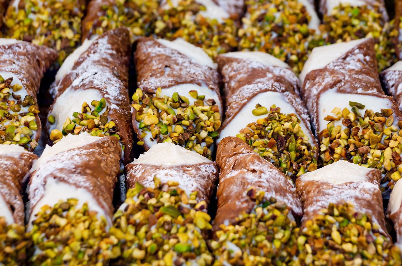 Lots of cannoli with chopped pistachio