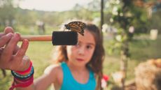 girl inspecting a copper butterfly