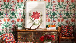 Colourful MINDTHEGAP wallpaper with matching chairs and wooden sideboard with framed flower poster