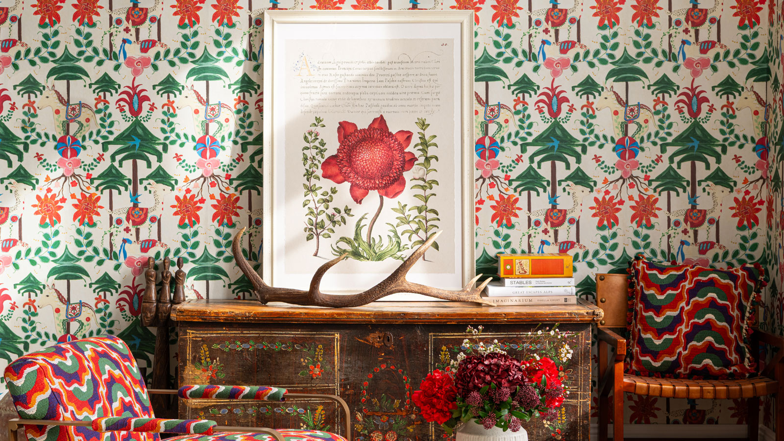 Colourful MINDTHEGAP wallpaper with matching chairs and wooden sideboard with framed flower poster
