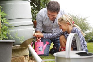 garden water saving tips: Father and daughter water butt