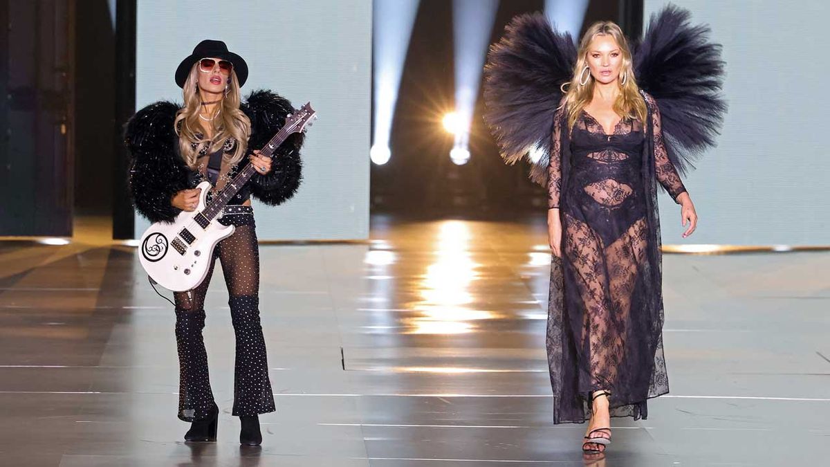 Orianthi plays guitar next to a catwalking Kate Moss at the Vicrtoria&#039;s Secret Fashion Show 