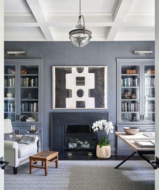 living room with gray walls, white ceiling, light gray carpet and fireplace with black and white artwork