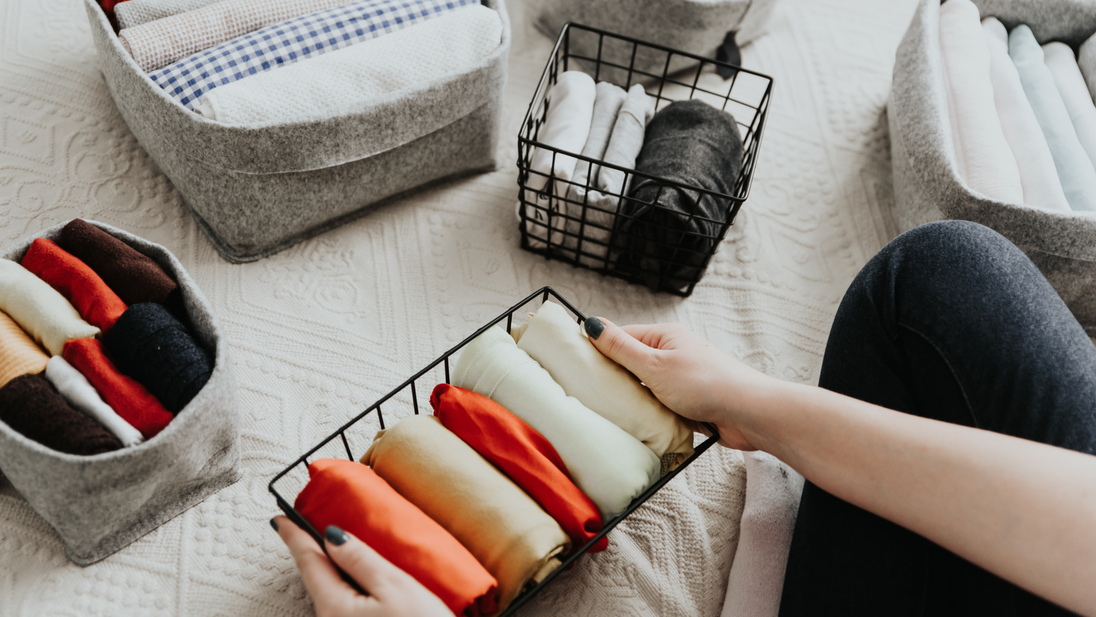storage baskets with folded items and products to show how to declutter a bedroom