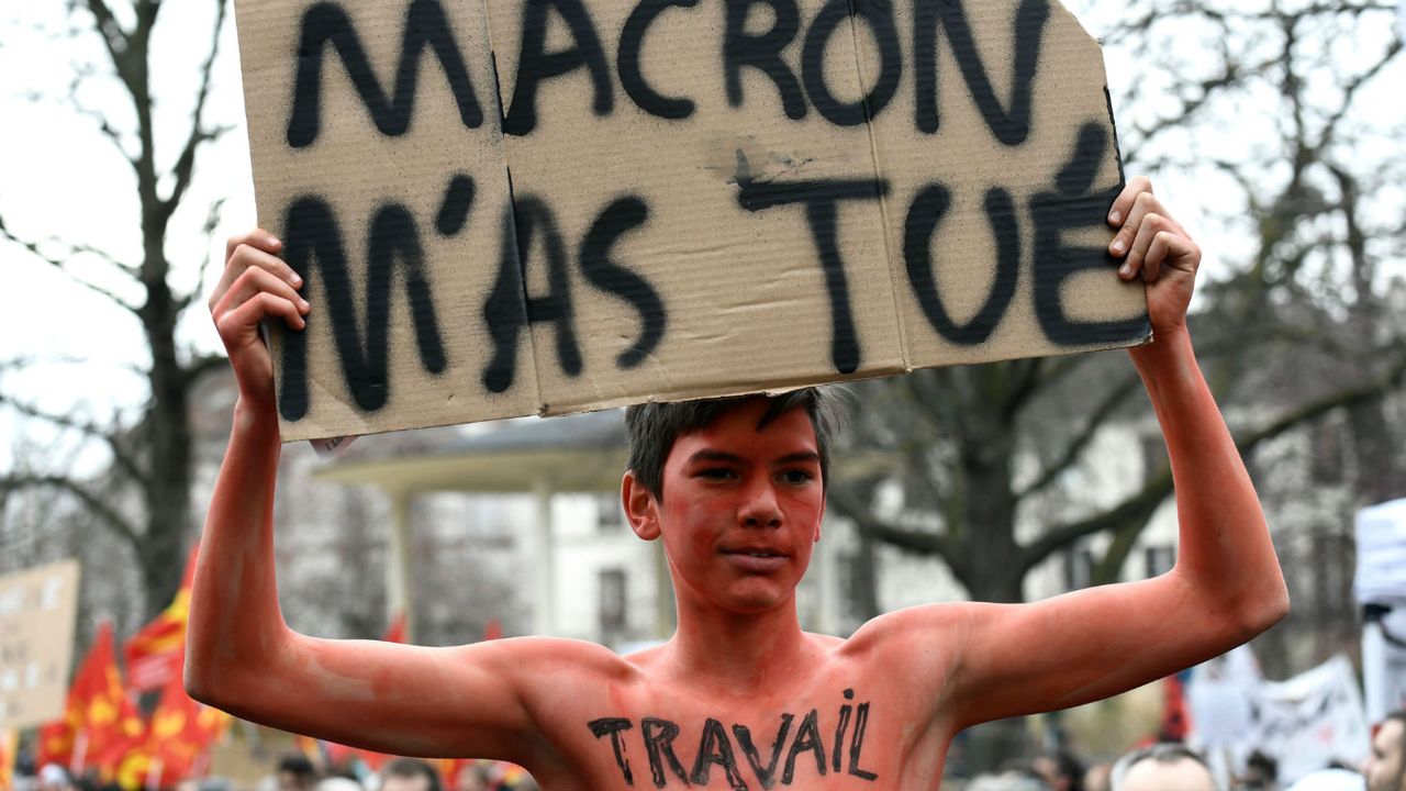 A protester dressed as &amp;#039;work&amp;#039; holds a banner which reads &amp;#039;Macron killed Me&amp;#039;