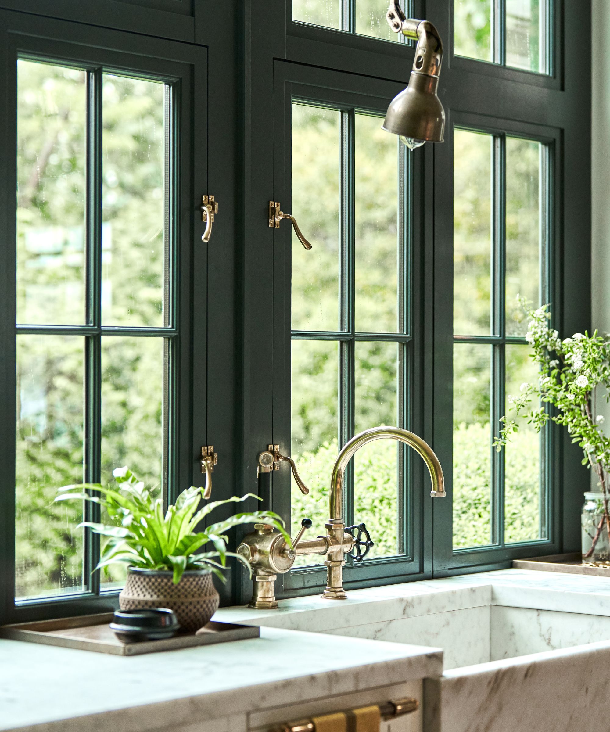 Marble topped sink in a window with brass taps