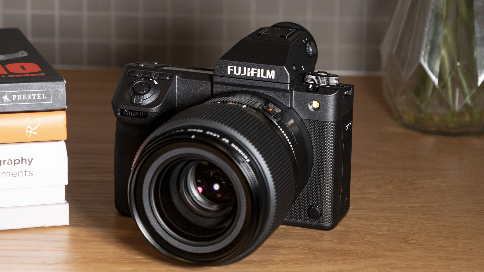 Fujifilm GFX100 II on a wooden table with GF 55mm F1.7 lens attached