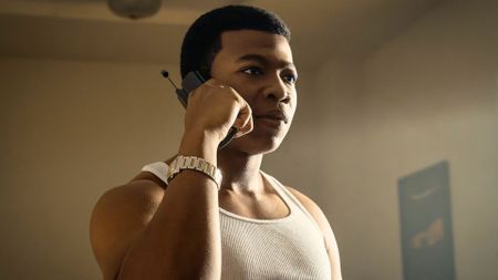 Kanan holds a phone to his ear