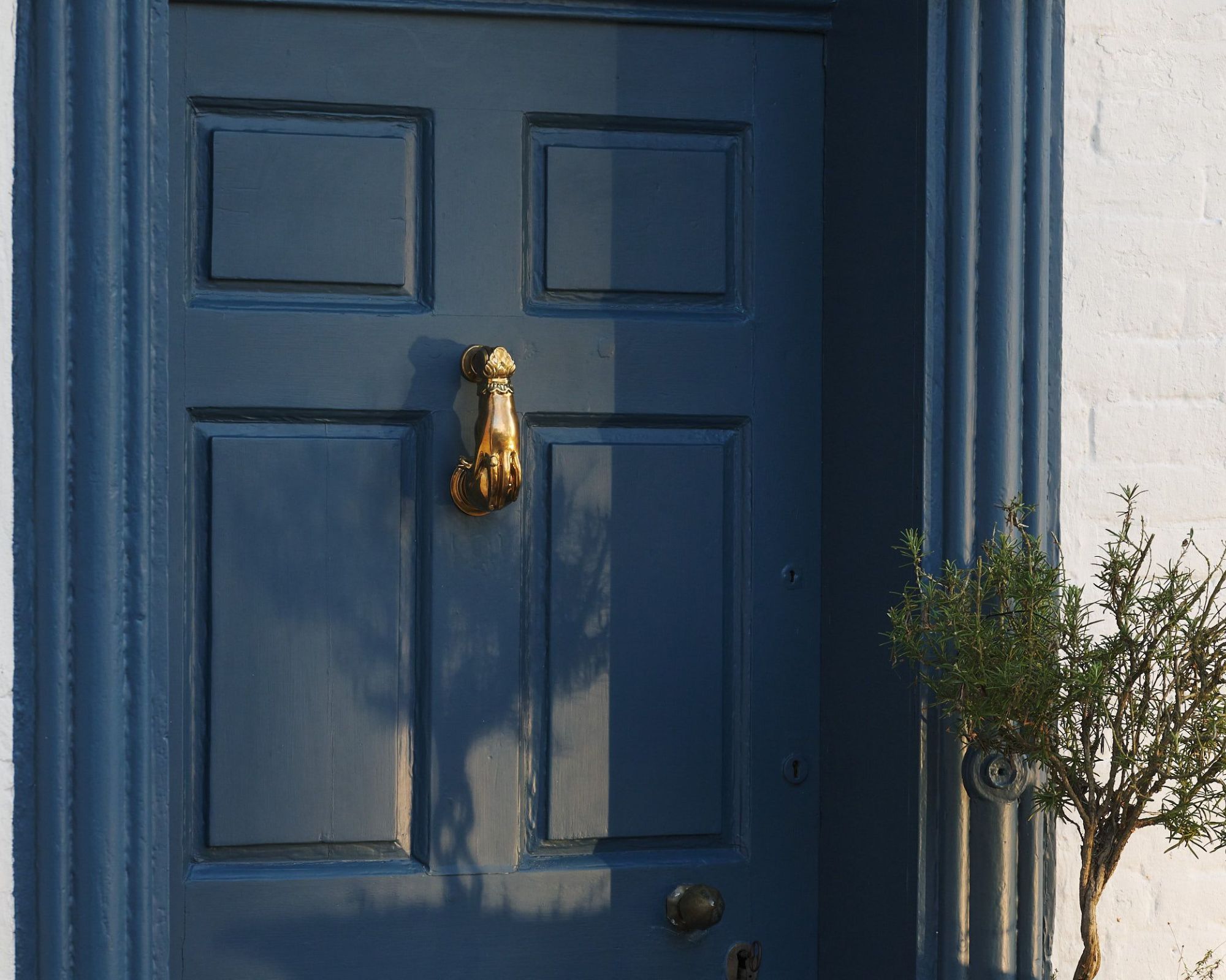 External shot of dark blue front door with brass knocker