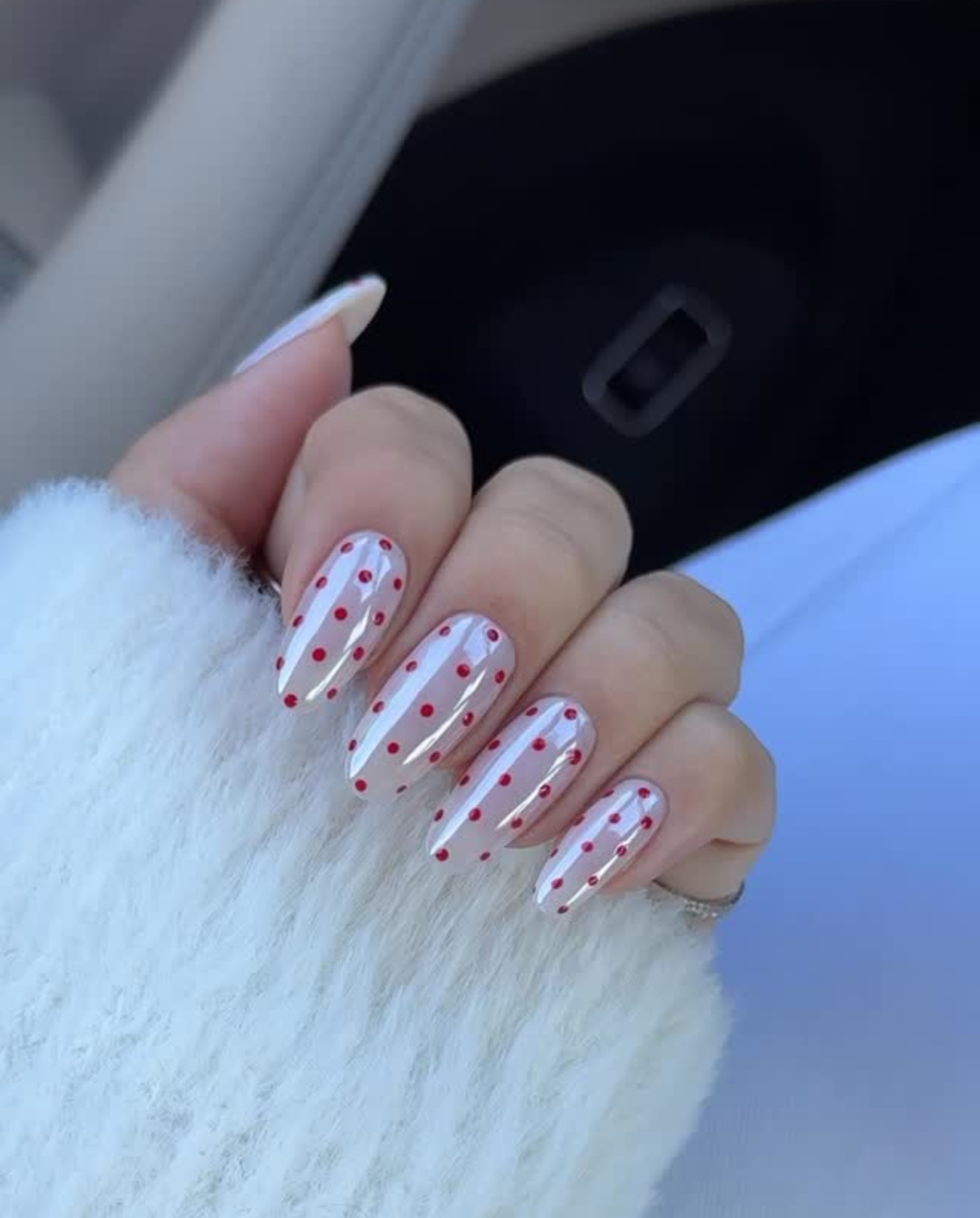 A chrome manicure with red polka dots by Zola Ganzorigt