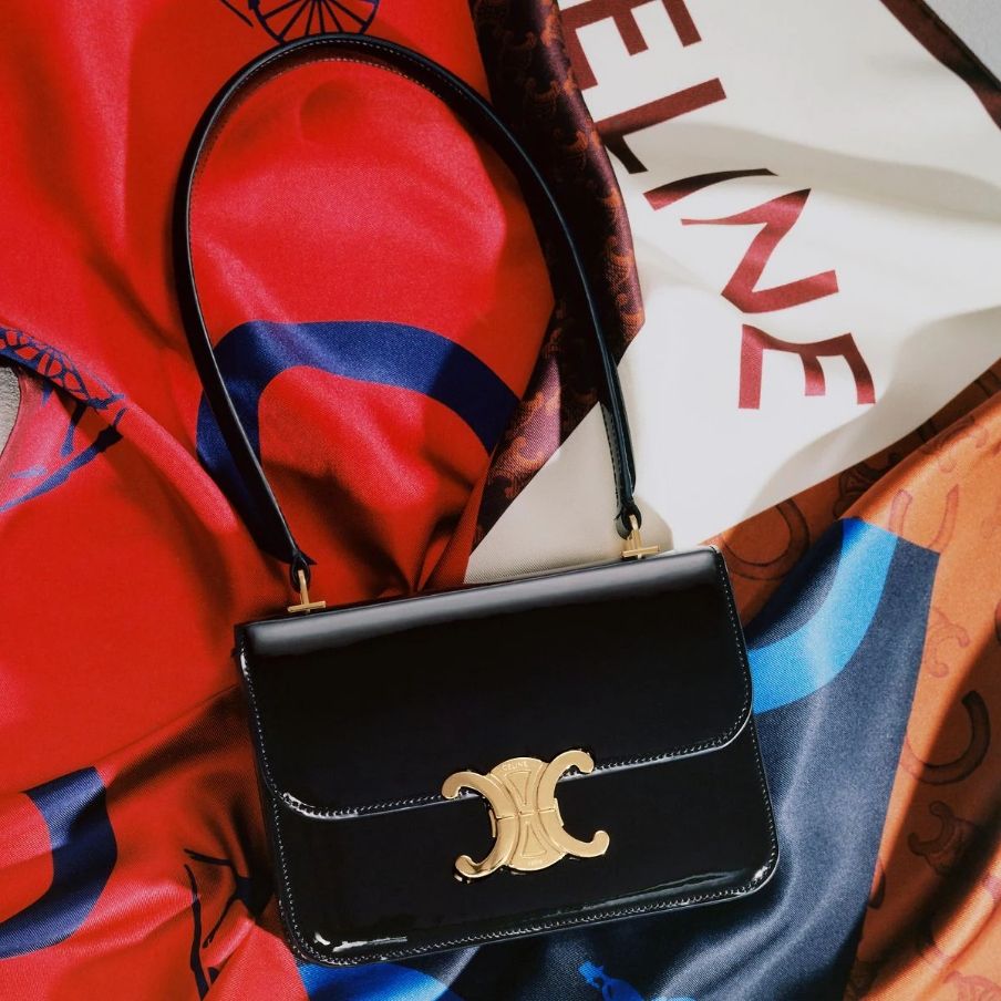 a photo of a black celine garance bag on top of colorful scarves
