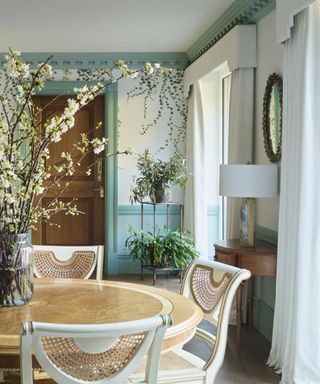 dining area with rattan chairs, aqua woodwork and trailing ivy wallpaper