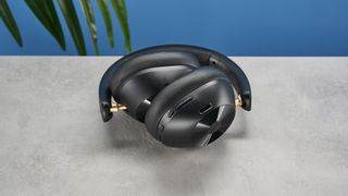 a pair of black bluetooth headphones made by OneOdio Focus A5 is photographed against a blue background