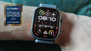 Apple Watch Ultra 2 on a man's wrist, with a sign saying TechRadar Choice Awards 2023