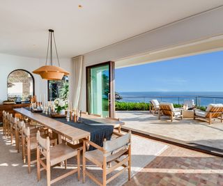 Malibu Mansion open plan dining room with floor to ceiling sliding glass doors leading to deck