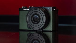 Panasonic Lumix S9 camera in Dark Olive color on a rich red reflective surface