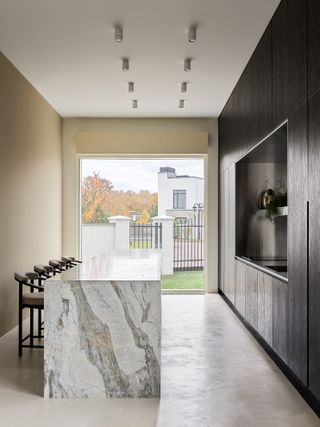 A kitchen with dark grey cabinets and beige walls
