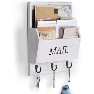 A white wall-mounted mail organizer with three black hooks filled with colored envelopes of different sizes